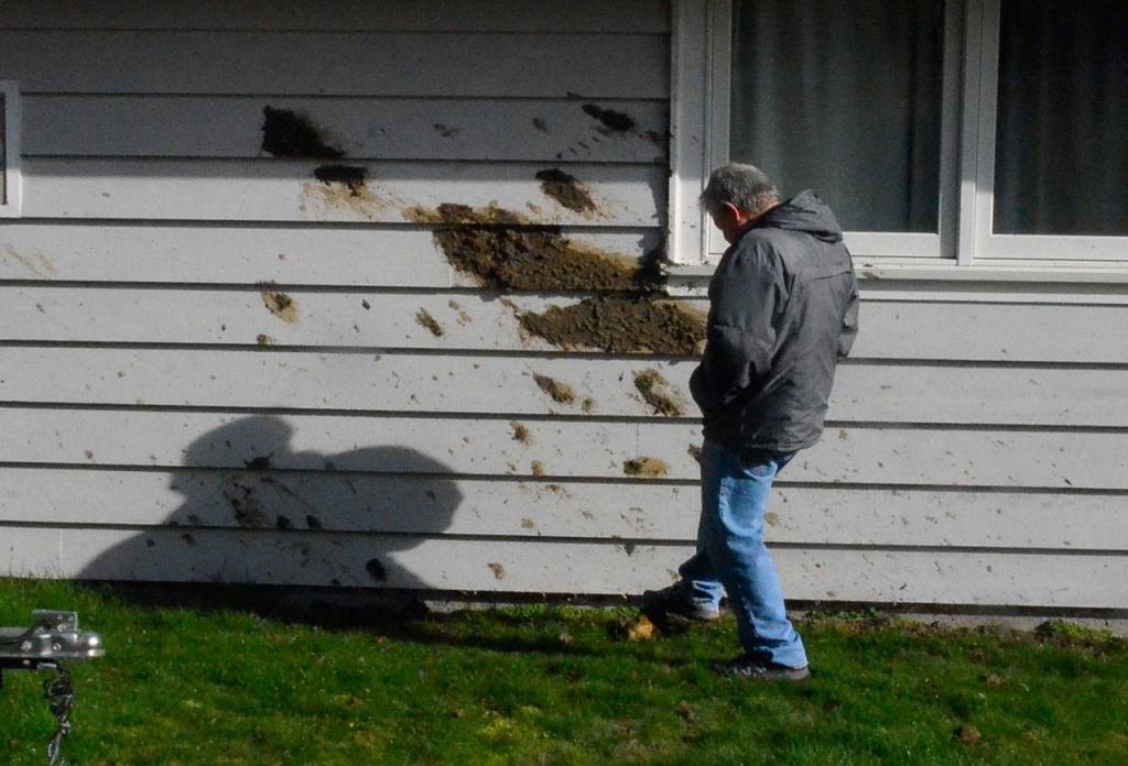 Justin Burnett/The Record &mdash; Rob Haines kicks a rock near mud that splattered on a neighbor&rsquo;s home during a mudslide which damaged his home Monday morning on Columbia Beach Drive in Clinton.