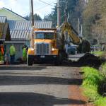 Justin Burnett/The Record &mdash; Island County Public Works road crews clear the last bit of debris from Columbia Beach Drive Monday morning. It was the second time they cleared the road that morning, following two slides that damaged a home.