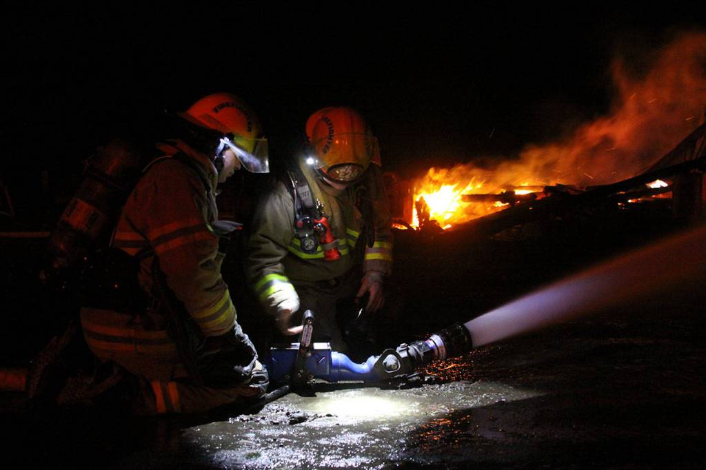 Firefighters attack the flames that engulfed the Smith Barn Monday night, March 6, 2017. Photo by Ron Newberry/Whidbey News-Times