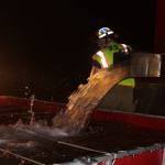 Firefighters fill a basin with water so it can be pumped to the engine near the burning Smith Barn. Photo by Ron Newberry/Whidbey News-Times