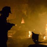 A firefighter battles a blaze that knocked out a Central Whidbey icon Monday night, March 6, 2017. The fire destroyed the historic Smith Barn at Willowood Farm in Coupeville. Photo by Megan Hansen/Whidbey News-Times