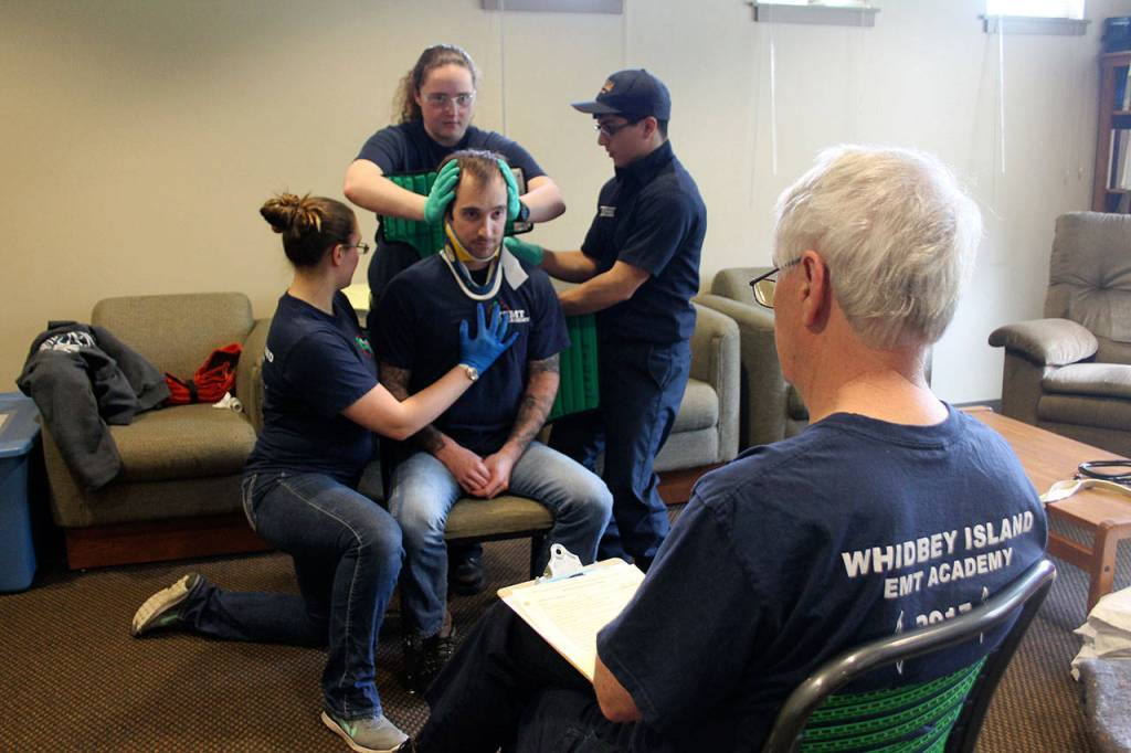 Kyle Jensen / The Record &mdash; Trainees practice securing &ldquo;patient&rdquo; David Mott to the Kendrick Extrication Device while instructor Ken Starkweather closes watches. The device is used to remove patients from vehicles in non-urgent situations.
