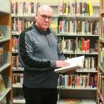 Poet Daniel Moore peruses books Wednesday at Oak Harbor Library, a member of Sno-Isle Libraries, which will sponsor a poetry reading of Moore&rsquo;s next month in Coupeville. Photo by Daniel Warn/Whidbey News-Times