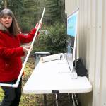 Photo by Patricia Guthrie/Whidbey News-Times                                Island County environmental health inspector Maribeth Crandell demonstrates a sludge stick used to measure accmulation in a septic tank. The above ground concrete tank and exposed pipes are used for education. Crandell begins teaching septic system safety to the public this month.
