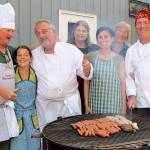Record file &mdash; Dan Saul (far left) grills hot dogs and hamburgers with other volunteers at the soup kitchen in Langley.