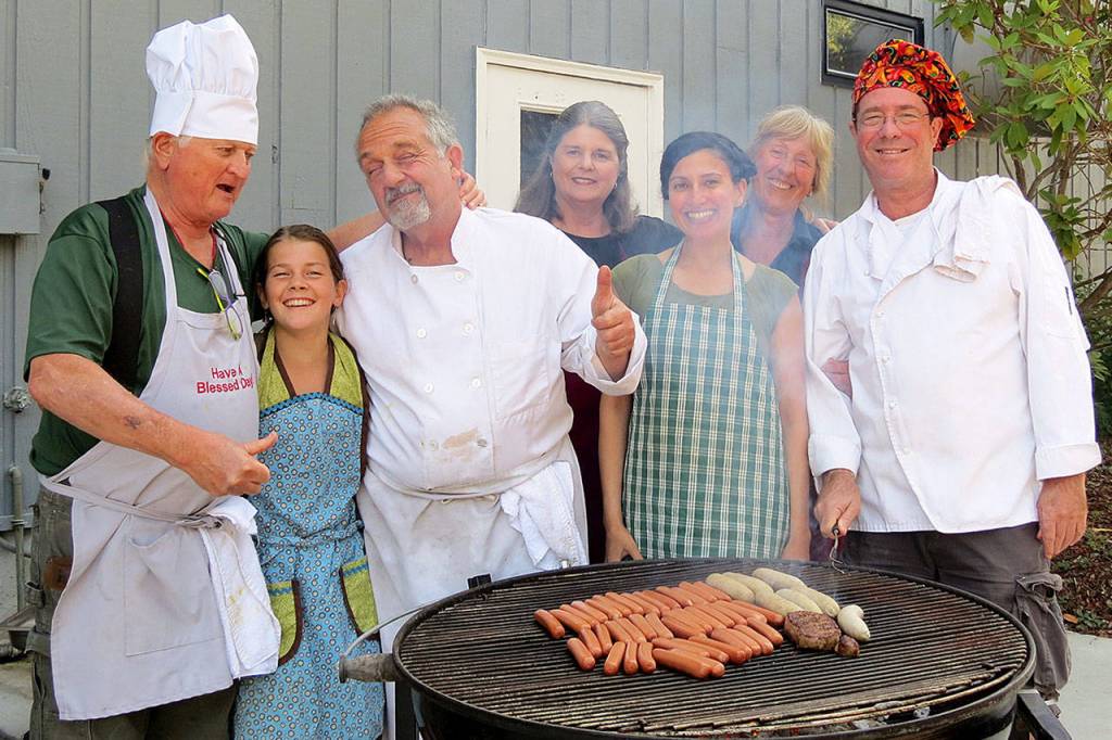 Record file &mdash; Dan Saul (far left) grills hot dogs and hamburgers with other volunteers at the soup kitchen in Langley.