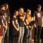 Evan Thompson / The Record &mdash; Kari Hustad, with microphone, sings during the Climate Arts Project&rsquo;s performance on Wednesday morning in South Whidbey High School&rsquo;s auditorium.