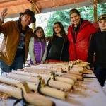 Whidbey Island Waldorf School photo &mdash; Paul Wagner (left), from the Saanich people and Angela Lindstrom (second from right) show students how to make flutes as part of the Potlatch program.