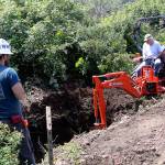 Craig Holmquist uses an excavator Monday, May 22, 2017 to dig a hole for a new vault toilet that will be installed in June near the office of Ebey&rsquo;s Landing National Historical Reserve in Coupeville. Carl Sholin, an archaeologist with the National Park Service, monitors the dig. The Reserve will be busy with several projects this summer as it braces for an increasing number of visitors. Photo by Ron Newberry/Whidbey News-Times