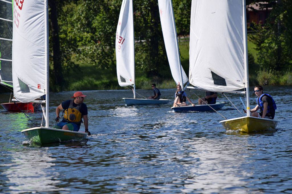 Kyle Jensen / The Record &mdash; Sailors race to the finish line, while Malbin (left) gives pointers to the younger sailors.