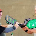 After a game, players Clare Kruse, Dave Meyer, and Barry Haworth (left to right) give the customary high-five slap of their pickle ball racquets. Getting together twice a week to play pickle ball is good for the heart and soul, friendships and fitness, say about 30 participants of the Oak Harbor Senior Center activity. Photo by Patricia Guthrie/Whidbey News-Times