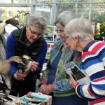 Contributed photo &mdash; Whidbey Audubon Society board member Ann Casey (left) discusses ducks with curious visitors at one of Audubon&rsquo;s &ldquo;bird in the hand&rdquo; events.