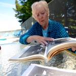 Justin Burnett/The Record &mdash; Betty Discher, the granddaughter of Minnie Spencer-Plumb, flips through a book about South Whidbey&rsquo;s history at the Honeymoon Lake Community Club&rsquo;s clubhouse.