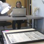 Evan Thompson / The Record &mdash; Jayne Keating, a volunteer and board member with the Island County Historical Society, works on digitizing old class photos of Langley High School students.
