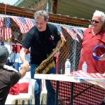 Record file &mdash; Danny Ward shakes the hand of a Maxwelton Independence Day Parade attendee in 2014. He&rsquo;s been playing The National Anthem at the annual event for years and is the 2017 grand marshal.