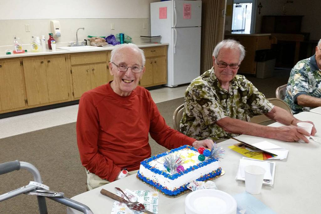 Contributed photo &mdash; Volunteers at Helping Hand celebrated his centennial after his volunteer shift last Wednesday.
