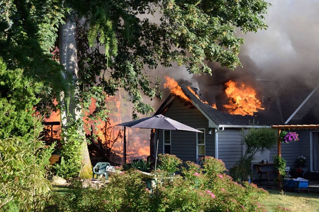 Kyle Jensen / The Record &mdash; The neighboring home also caught fire after propane tanks went up in flames.