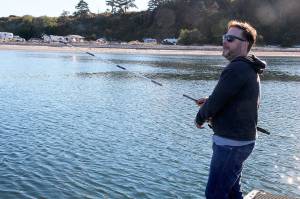 Monday at dusk, Brian Corbett casts his line from a dock near Coupeville Ferry Landing. Nothing came back, no pinks, no silvers, no dinner. &ldquo;I guess we&rsquo;re just out here fishing for compliments,&rdquo; said the visitor from New Jersey. Photo by Patricia Guthrie/Whidbey News-Times