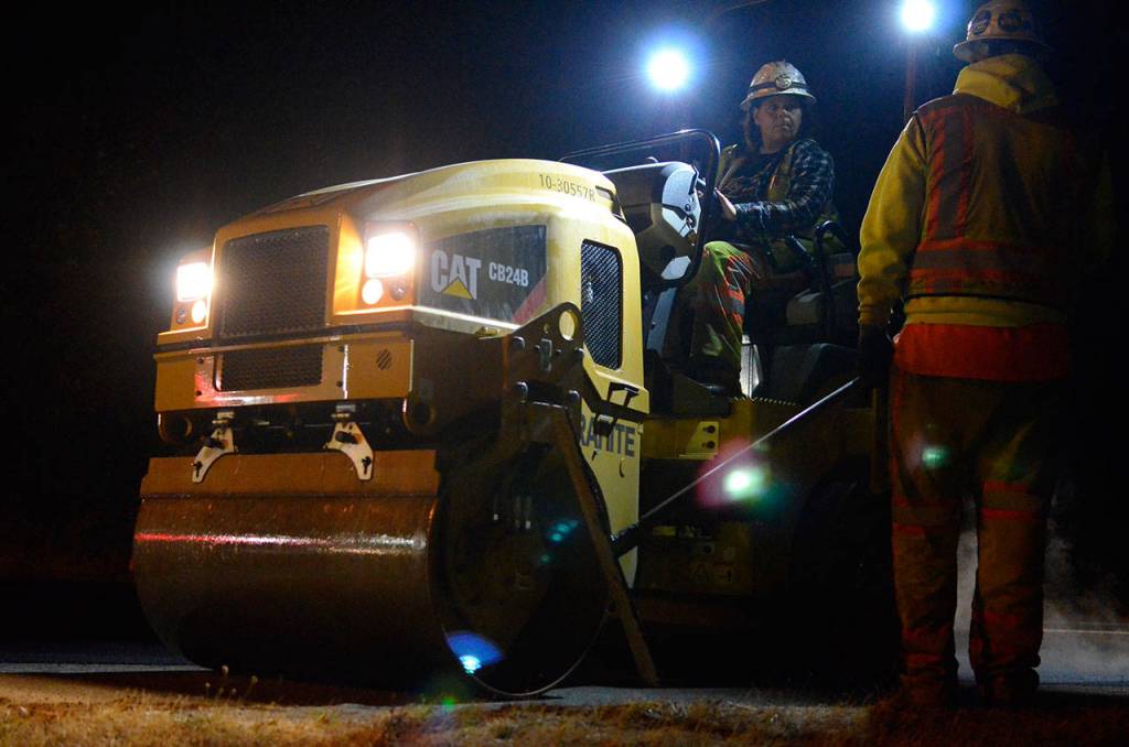 Justin Burnett/The Record &mdash; Julie Sell with Granite Construction speaks with a colleague before rolling freshly laid asphalt in Freeland on Thursday.