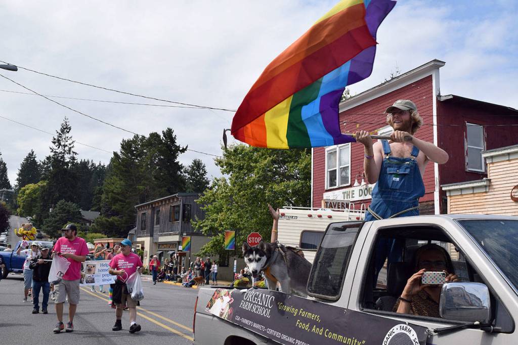 Kyle Jensen / The Record &mdash; A demonstrator waves the signature rainbow flag, one of many flown during Sunday&rsquo;s parade.