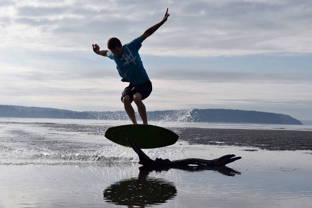 Kyle Jensen / The Record &mdash; Reisman jumps over a piece of driftwood Friday morning.