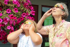 Patricia Guthrie / Whidbey News Group &mdash; Barbara Fournier and her great granddaughter Kayla Cooks try out glasses they&rsquo;ll be using in Oregon during Monday&rsquo;s 2017 Total Solar Eclipse. At a recent solar eclipse informational talk at Coupeville Library, Ruth and Andy Nielson of the Island County Astronomical Society talked about the features of the eclipse and the importance of wearing proper eye protection. Teens also made a nebula with jars and paints.
