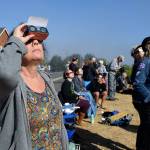 Kyle Jensen / The Record                                Clinton resident Tricia Bozin gazes at the partial solar eclipse alongside others in a crowd on Cascade Avenue.