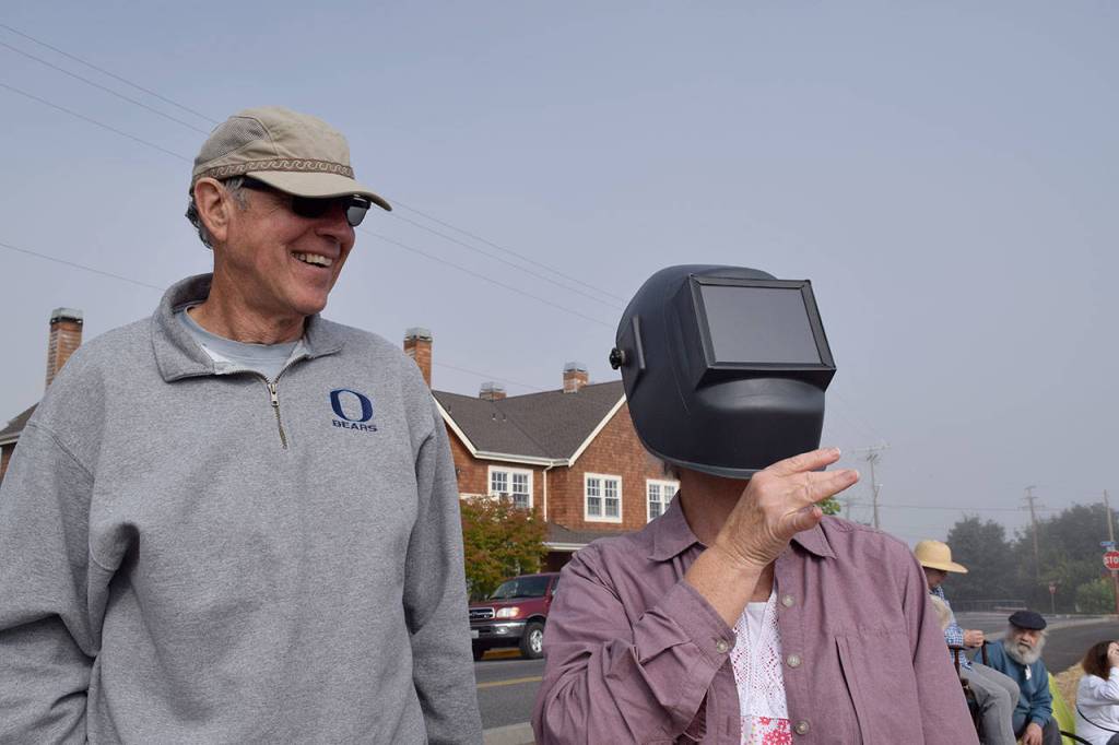 Kyle Jensen / The Record                                Adna, Wash. resident Sandy Burnett uses her husband John&rsquo;s welding mask to gaze at the partial solar eclipse.