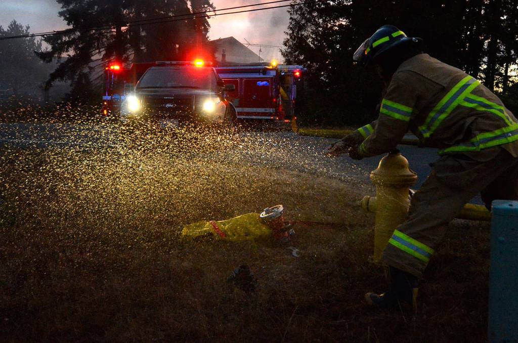 Justin Burnett/The Record &mdash; A South Whidbey Fire/EMS firefighter turns on a fire hydrant on Honeymoon Bay Road.