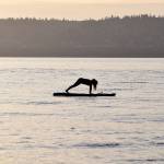 Kyle Jensen / The Record &mdash; Aja Stewart, of Clinton, holds a yoga pose on the water during a Friday morning session.