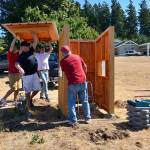 Justin Burnett/The Record &mdash; Brandon Fenton, 17, hoists the roof of a new shelter he built for Good Cheer Food Bank with the help of his father John Fenton, friend Chase Coffman and grandfather Mike Harper.