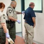 Photo by Jessie Stensland / Whidbey News-Times &mdash; Corrections deputies at the Island County Superior Court process a man who was arrested and brought into the jail for booking.