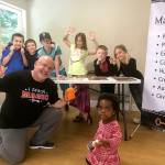 Contributed photo &mdash; Oak Harbor-based magician JR Russell, front left, teaches his pupils entry level tricks and illusions while coaching them on valuable life skills.