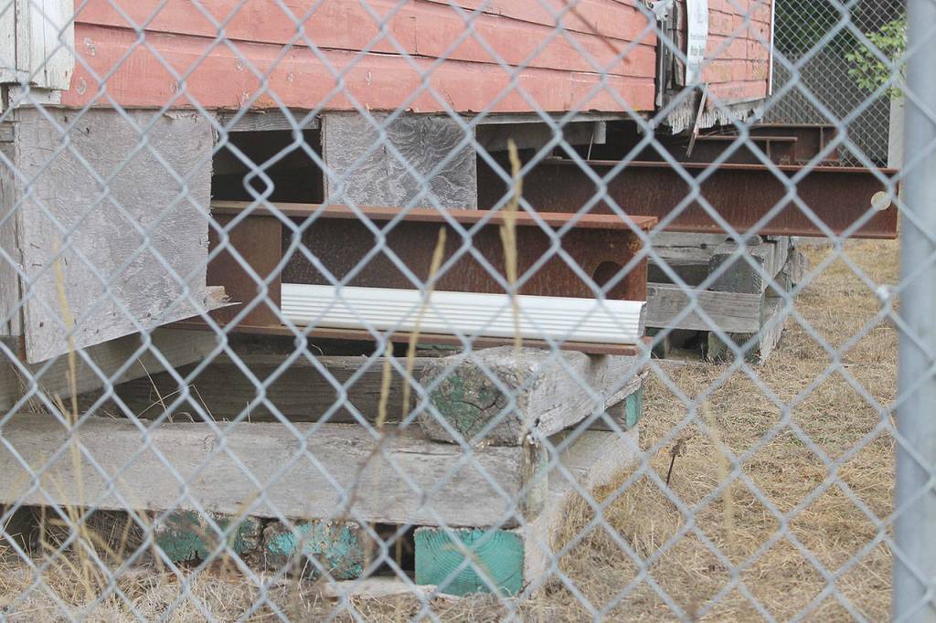Evan Thompson / The Record &mdash; The foundations of the &ldquo;Little Red Building&rdquo; currently sit atop blocks. If there weren&rsquo;t fences surrounding the structure, the City of Langley would consider it safety nuisance.