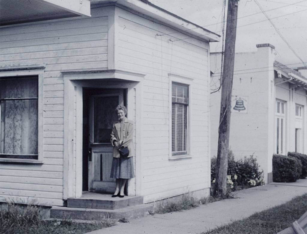 Contributed photo &mdash; A picture of the &ldquo;Little Red Building&rdquo; when it was in downtown Langley in the mid-1950s. It was painted white at the time. Standing in the photo is Elizabeth Henny, George Henny&rsquo;s grandmother. The photo was taken by David Henny, George Henny&rsquo;s father.