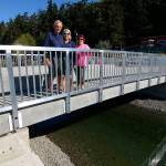 Justin Burnett/The Record &mdash; Lagoon Point Community Association President Duane Rawson, along with assistant secretary Christine Anderson and assistant treasurer Cheryl Kuss pose for a picture on the recently rebuilt Seashore Avenue Bridge. It replaced an older wooden structure and is one of two privately owned bridges in Island County.