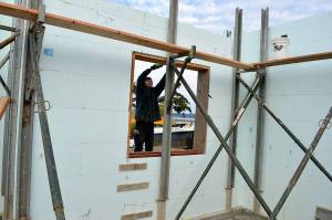 Nevin Miranda of Viewridge Construction installs a window frame on a new house being built on Leach St NE. The county recently released a survey to determine residents&rsquo; satisfaction with housing in Island County. Photo by Laura Guido/Whidbey News-Times