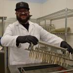 Kyle Jensen / The Record &mdash; Whidbey Island Ice Cream employee Joe Valencia prepares to put sticks in the company&rsquo;s ice cream bars before they freeze.