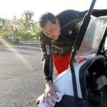 Evan Thompson / The Record &mdash; Holmes Harbor Golf Course operator Paul Lavin wipes down a golf cart on Tuesday morning in preparation for the day. Behind him is the parking lot that has been the source of dispute since 2014.
