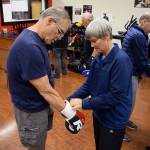 Kyle Jensen / The Record  Trainer Sue Taves helps a boxer put on his gloves before the session starts. Taves doesnt have a background in boxing, but was brought into the program as a physical therapist.