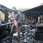 Photo by Jessie Stensland / Whidbey News-Times                                North Whidbey resident Karl Nielsen examines a board inside his wood shop that was destroyed by a Nov. 29 fire.