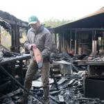 Photo by Jessie Stensland / Whidbey News-Times                                North Whidbey resident Karl Nielsen examines a board inside his wood shop that was destroyed by a Nov. 29 fire.