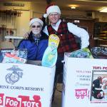 Evan Thompson / The Record  Ron Whitman and Kevin Lungren of The Fishin Club pose for a shot behind two boxes of toys collected by Toys for Tots, a program run by Col. Richard Buck Francisco Marine Corps League Detachment No. 1451. The clubs members will make deliveries to needy families around South Whidbey before Christmas.