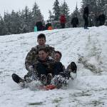 Kyle Jensen / The Record  Kids piled onto the same board to pick up maximum speed down a hill at Community Park in February.