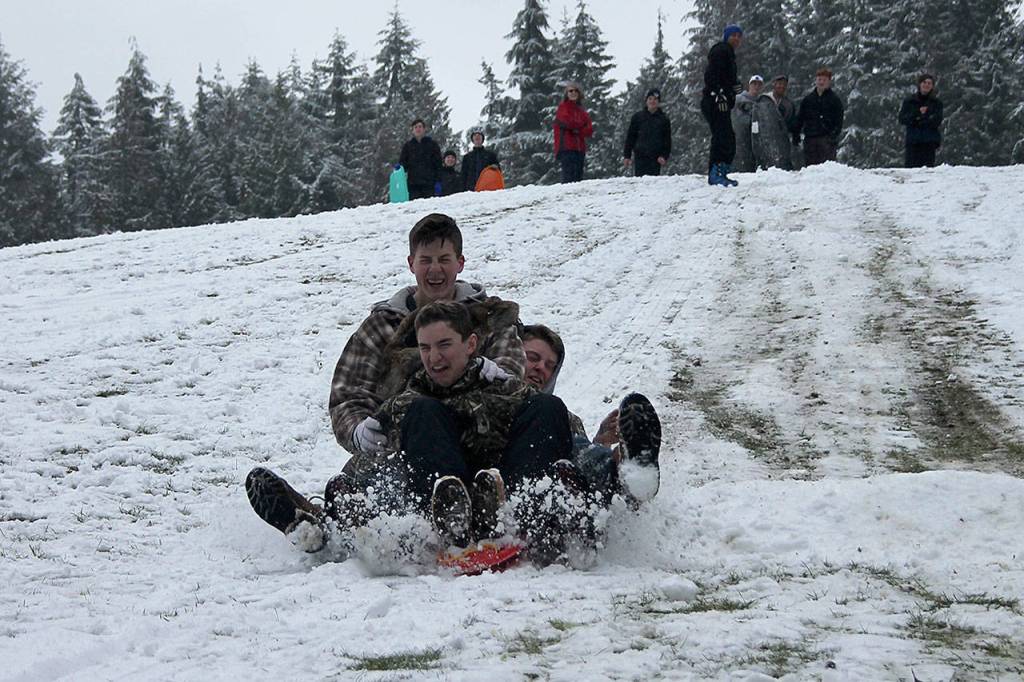 Kyle Jensen / The Record  Kids piled onto the same board to pick up maximum speed down a hill at Community Park in February.