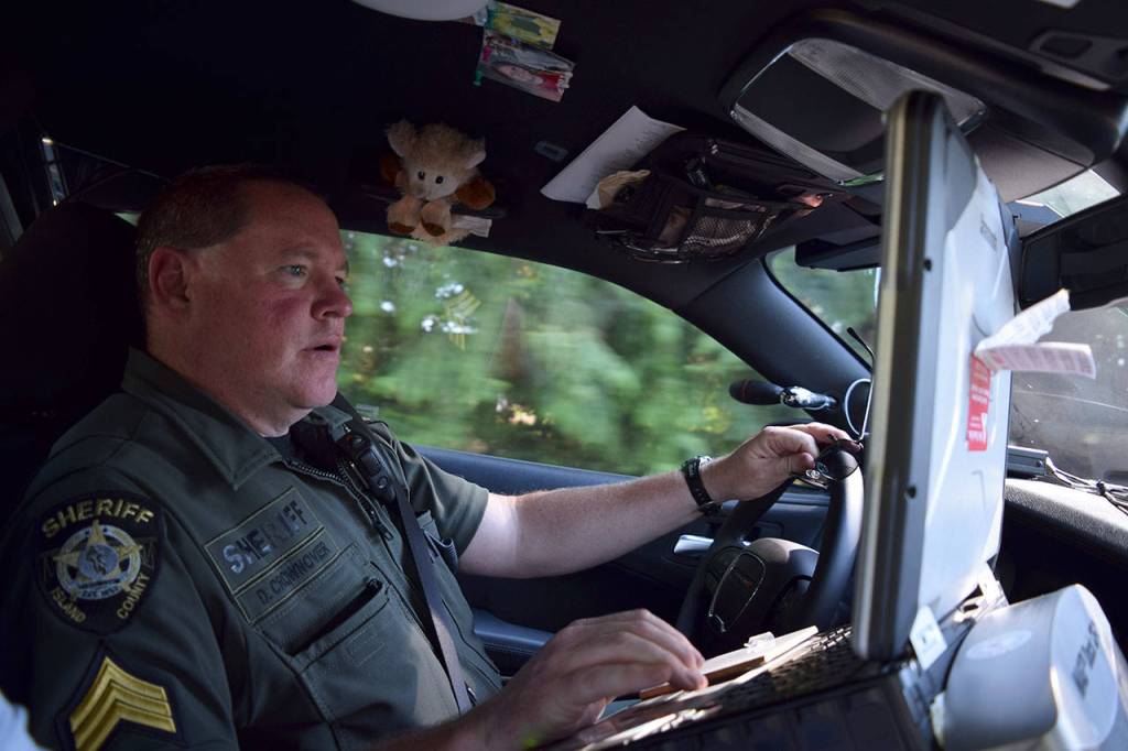 Kyle Jensen / The Record  Sgt. Darren Crownover checks license plate numbers in the sheriffs office database while patrolling high-activity houses. He says there are 5 houses on South Whidbey the sheriffs office has its eye on.