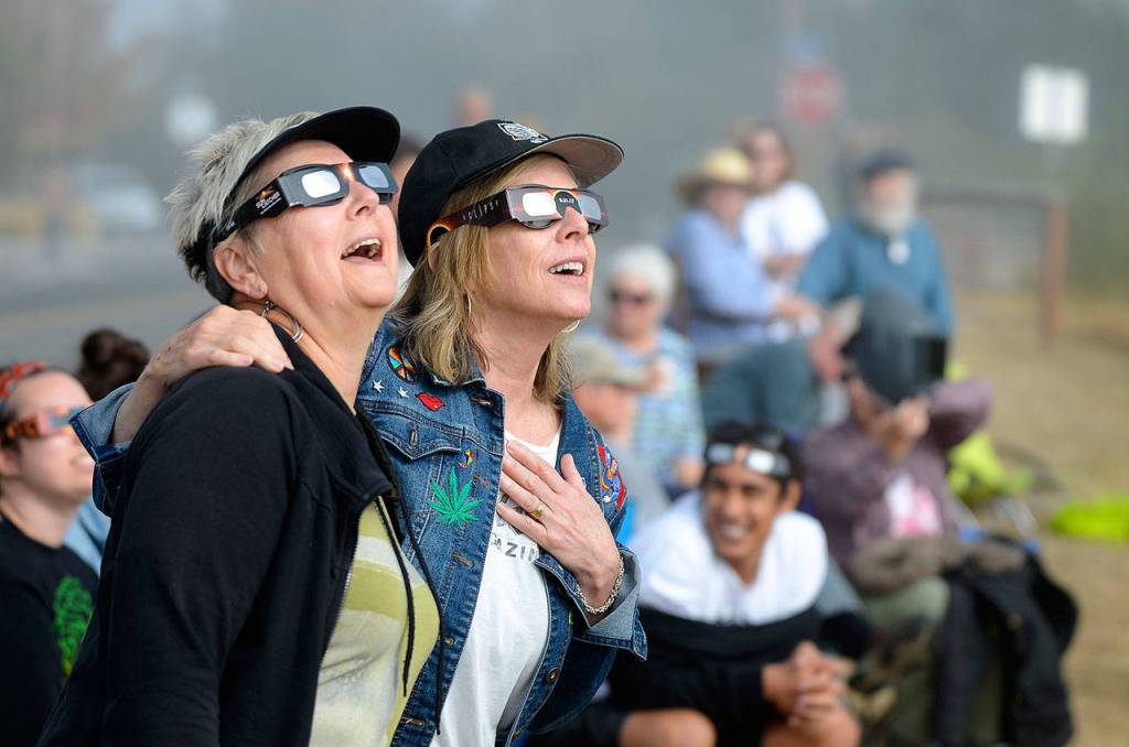 Justin Burnett / The Record  Langley residents Nancy Loorem Adams (left) and Debbie Loudon (right) sing along to Bonnie Tylers Total Eclipse of the Heart during Augusts partial solar eclipse.