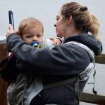 Kyle Jensen / The Record  A woman takes a selfie with her baby holding her sea float.