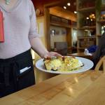 Kyle Jensen / The Record  A server brings out eggs benedict during lunch on Monday.