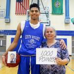 Evan Thompson / The Record  South Whidbey senior Lewis Pope holds a basketball with a picture of his late father, Henry Pope, with his mother Teresa Pope at his side. Pope recently eclipsed 1,000 points scored in his career for the Falcons boys basketball team.